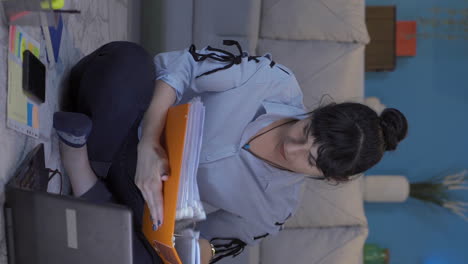 Vertical-video-of-Home-office-worker-woman-reviewing-paperwork-files.